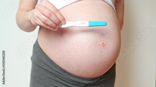 Positive pregnancy test and pregnant belly, ninth month, fertility