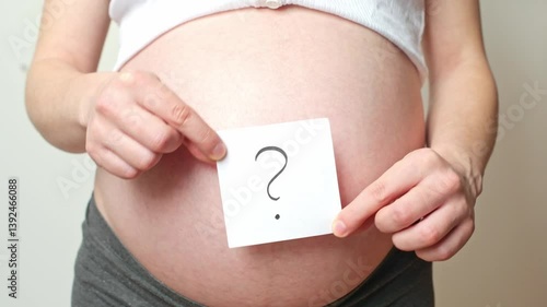 card with a question mark on a pregnant belly, baby's gender