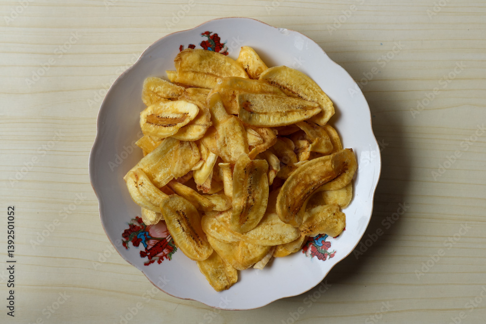 Keripik pisang or Banana chips on a white plate Keripik pisang or Banana chips on a white plate