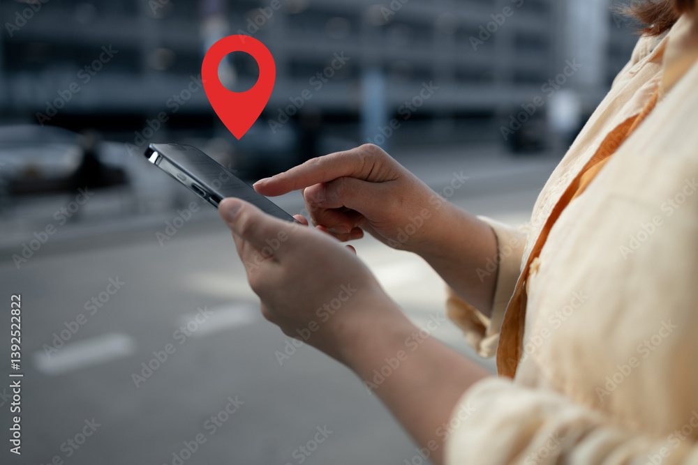 A woman is holding her smartphone with her finger on the screen, displaying a location pin icon. This image represents digital navigation or map apps for location-based services and travel.
