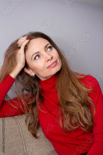 Принти на полотні An adult woman smiles and looks up dreamily.