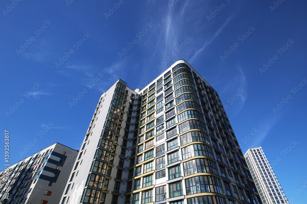 A very tall building stands prominently beneath a clear blue sky A very tall building stands prominently beneath a clear blue sky