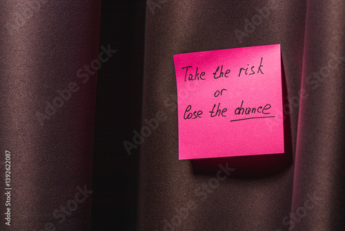 Motivational note says take the risk or lose the chance on a curtain