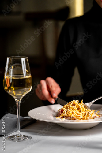Canvastavla A stylish setting featuring a glass of white wine beside a plate of pasta