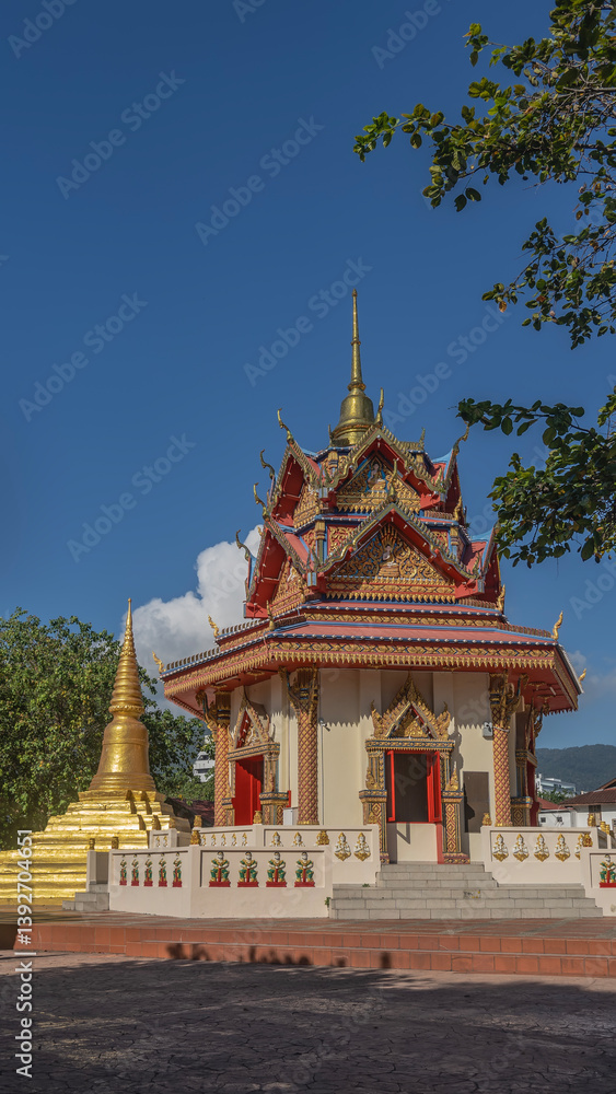 Beautiful Buddhist temple. The roof of the pagoda features triangular cornices, gilded ornaments, and decorative sculptures. A stupa and a spire against the blue sky. Malaysia. Penang. Georgetown Beautiful Buddhist temple. The roof of the pagoda features triangular cornices, gilded ornaments, and decorative sculptures. A stupa and a spire against the blue sky. Malaysia. Penang. Georgetown