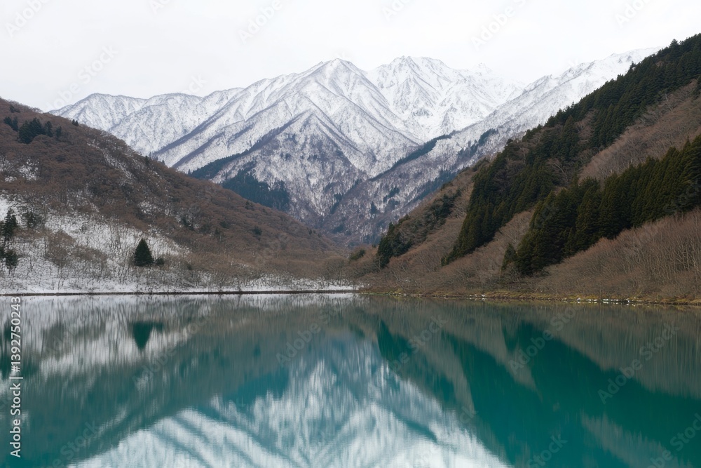Snowy mountains reflecting on a calm, turquoise lake under an overcast sky Snowy mountains reflecting on a calm, turquoise lake under an overcast sky
