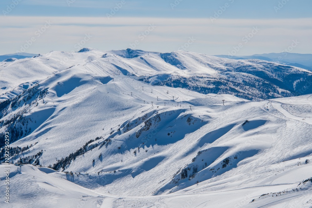 Fototapeta premium Snowy mountains under a clear sky create a beautiful, winter landscape