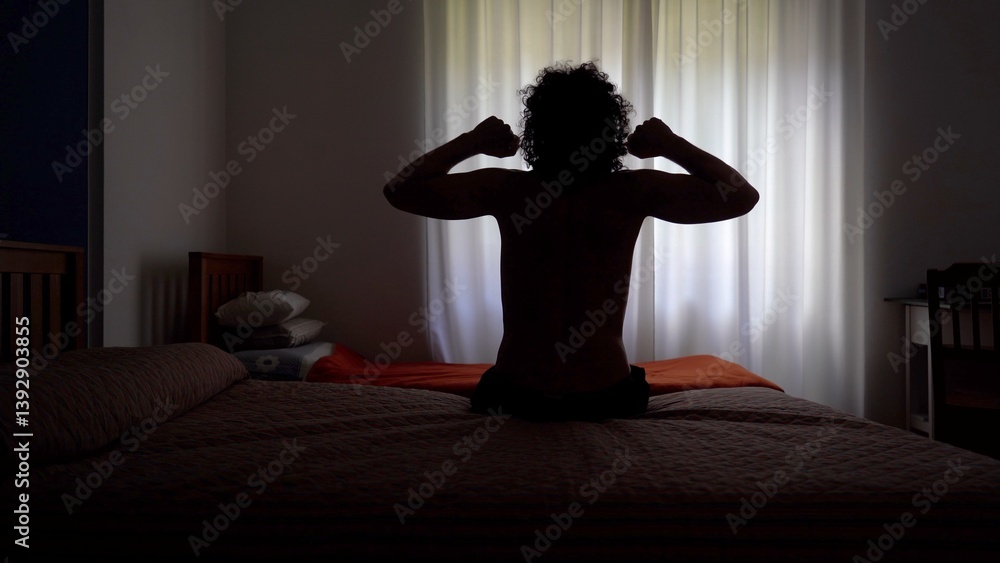 Man wakes up in the morning and gets out of bed to open the window curtains and look out of the house ready to start a new day - lifestyle in apartment
