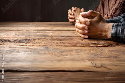 Two individuals clasping hands at a wooden table, conveying a sense of tranquility and introspection