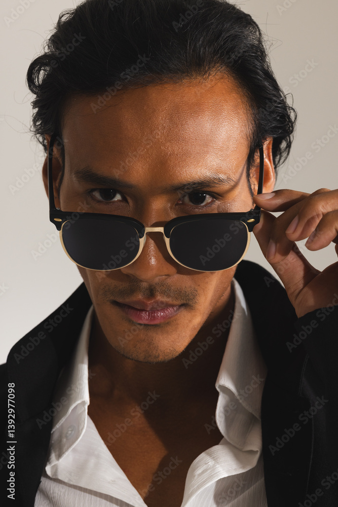 Confident man adjusting sunglasses, wearing stylish black jacket and white shirt Confident man adjusting sunglasses, wearing stylish black jacket and white shirt