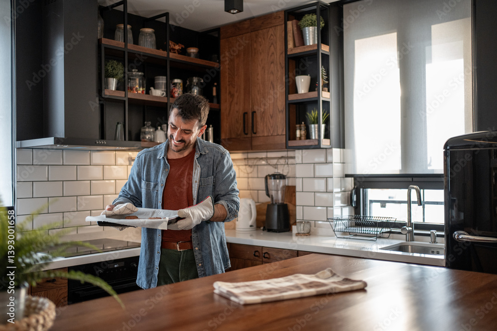 Happy man baking cookies in modern kitchen Happy man baking cookies in modern kitchen