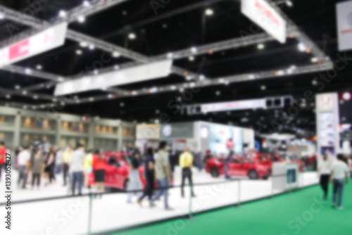 Defocused blurry crowd anonymous people walking at exhibition trade fair at convention event or conference hall. light bokeh background.