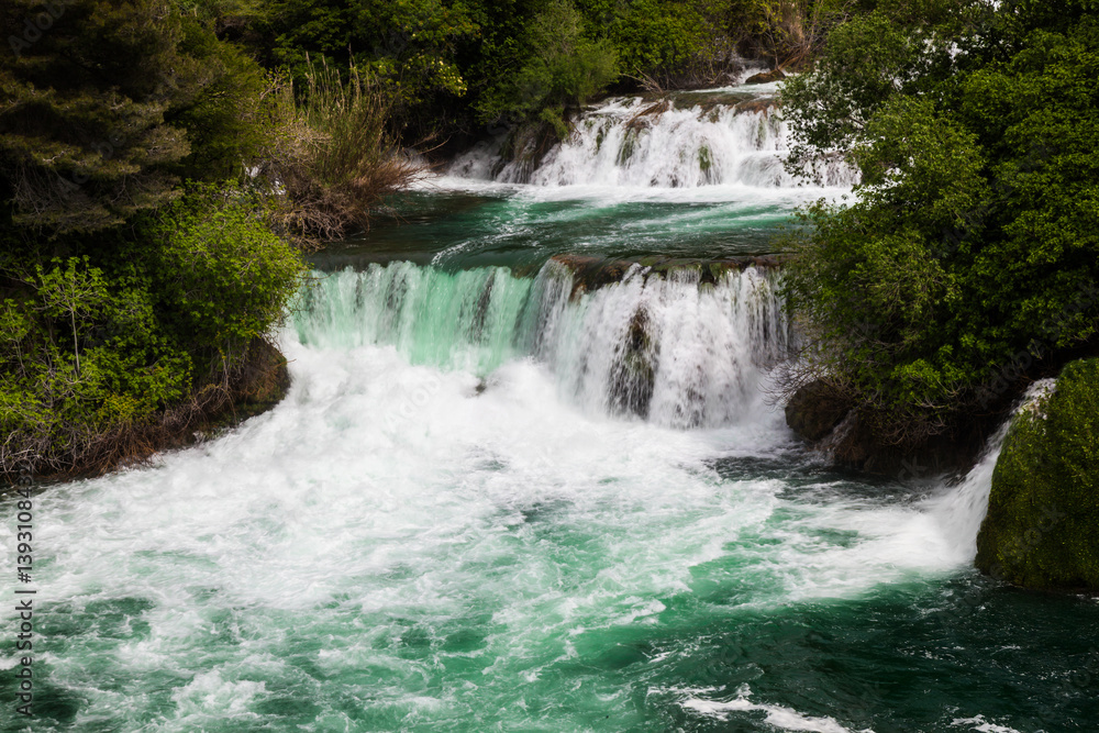 Scenic view of cascading waterfalls surrounded by lush green vegetation in a serene natural landscape Scenic view of cascading waterfalls surrounded by lush green vegetation in a serene natural landscape