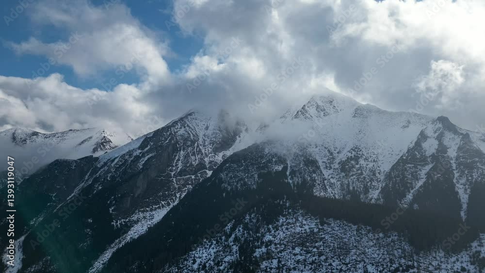 Aerial hyper lapse of snowy mountains landscape with clouds motion fast.