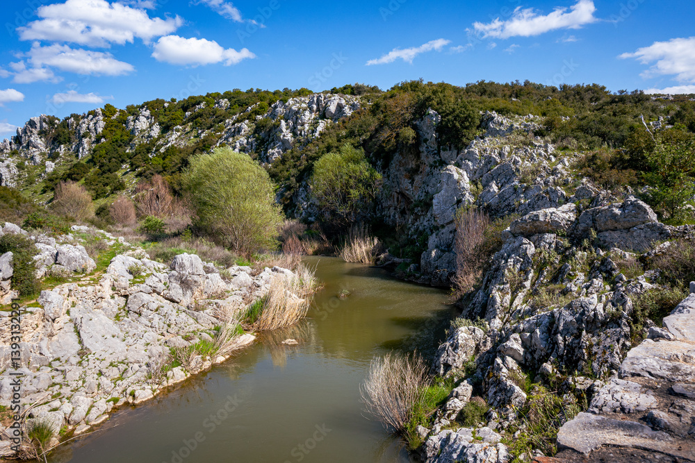 Photo shows a part of Asopos river located at Boeotia-Greece crossing through mountain. Blue cloudy sky at the background, beautiful scenery. Photo shows a part of Asopos river located at Boeotia-Greece crossing through mountain. Blue cloudy sky at the background, beautiful scenery.