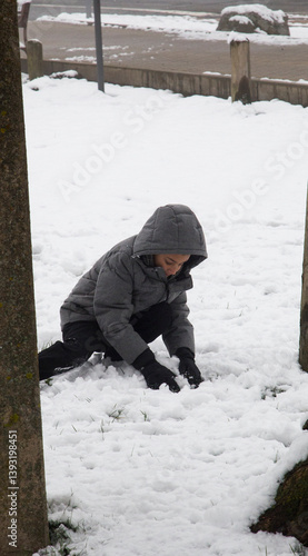 Child making snowballs to play