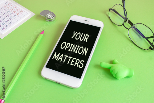 Your opinion matters symbol. Concept words Your opinion matters written on the mobile phone screen. Beautiful green background. Glasses, coins. Business concept.