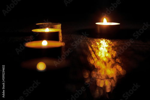 Memory day.Candles burning on a black background. The concept of grief, grief, mourning. You can use it as a banner.