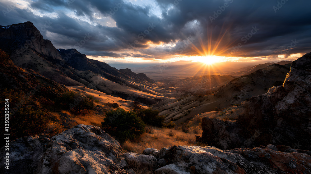 Obraz premium The evening sky turns soft pink as the sun sets behind the mountain range, casting gentle light over the rocky terrain below.