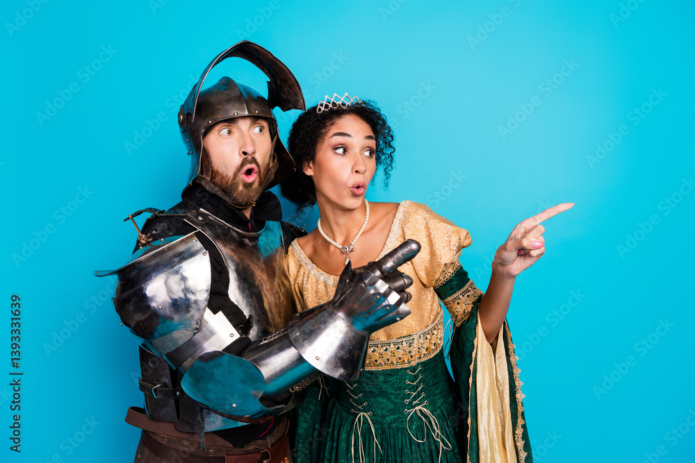 Medieval knight and princess pointing together against a vivid blue background, expressing surprise and curiosity Medieval knight and princess pointing together against a vivid blue background, expressing surprise and curiosity