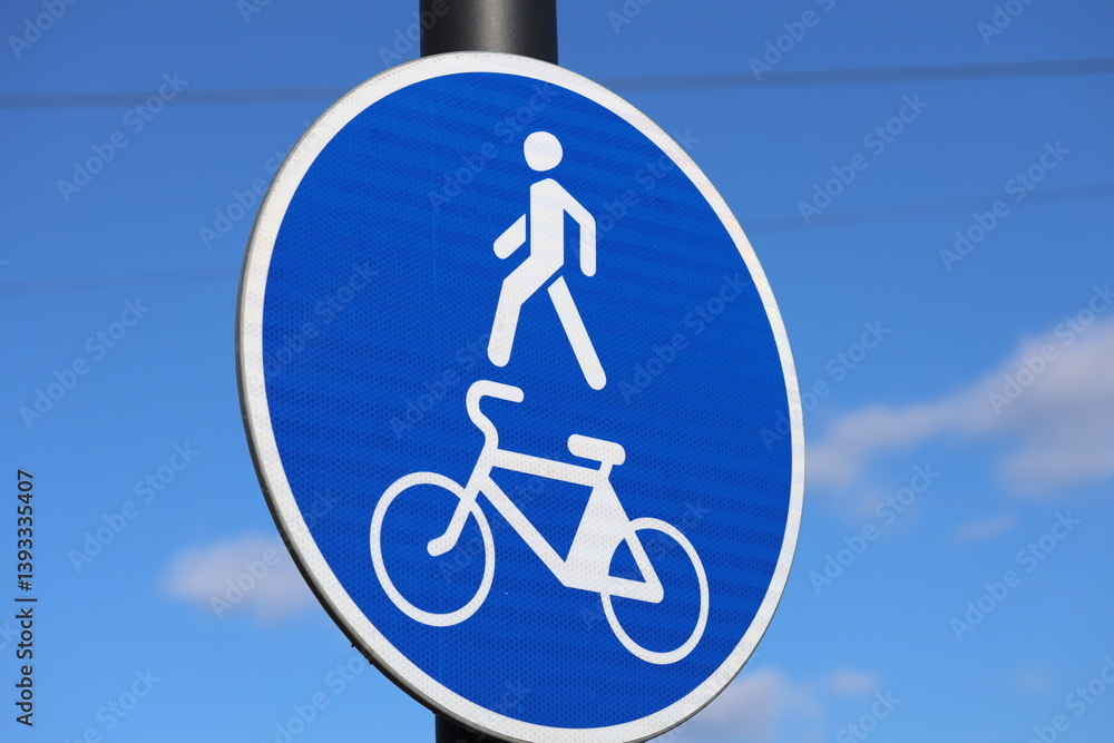 A person riding a bicycle near a street sign.