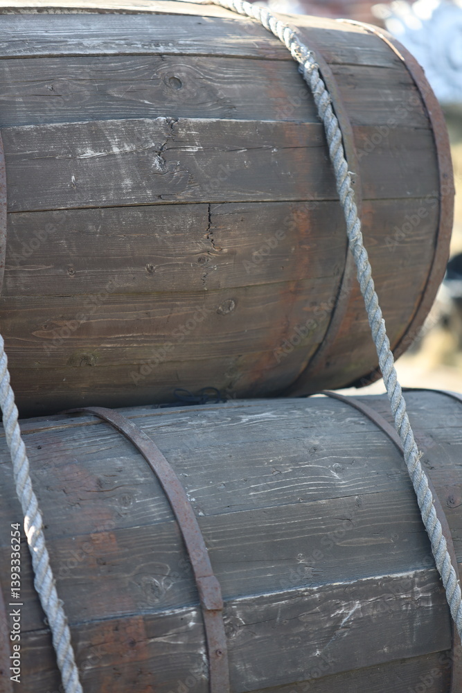 A rustic scene with two wooden barrels suspended from a rope, suitable for use in country-themed or outdoor settings.