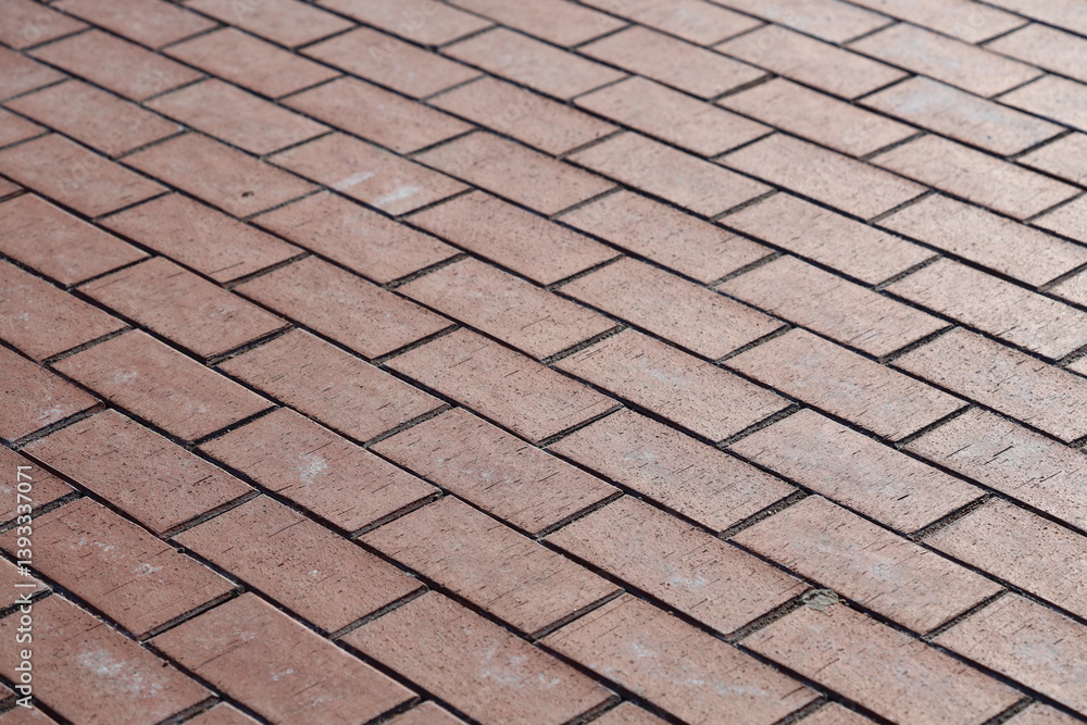Close-up shot of a worn red brick sidewalk with subtle texture and imperfections.