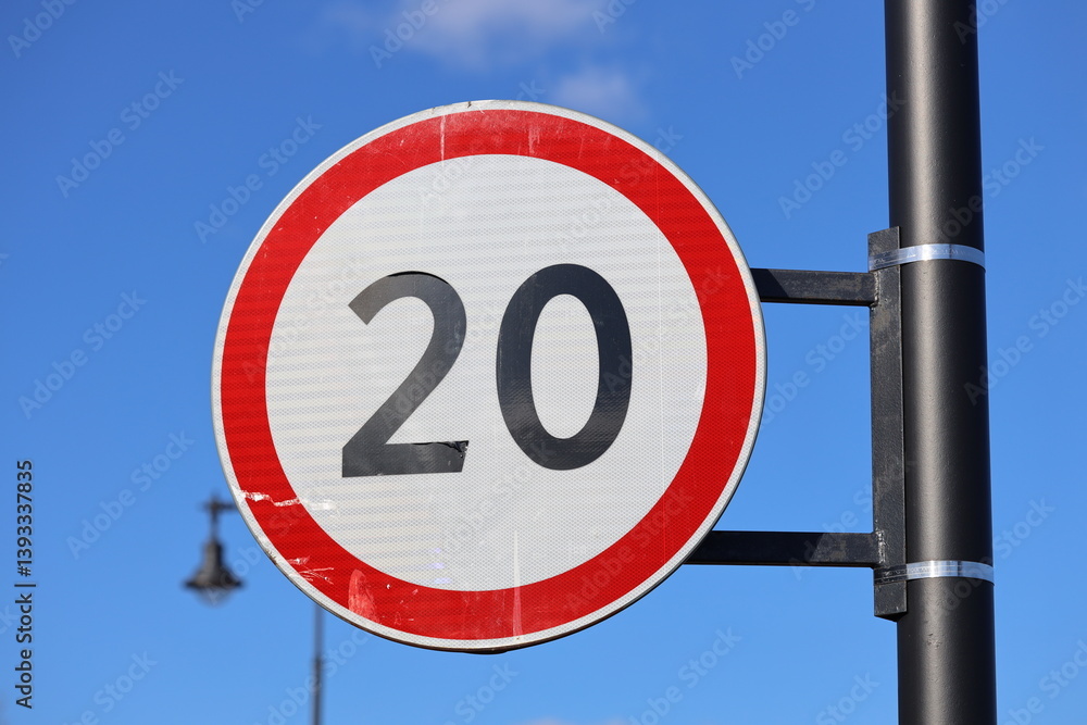 A bright red and white sign with the number 20 prominently displayed.