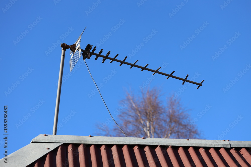 TV antenna installed on the rooftop, suitable for use in urban or suburban settings.