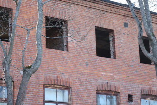 Obraz na płótnie A brick building with multiple windows and a birdhouse attached to the side, perfect for architecture or nature-inspired designs. w salonie