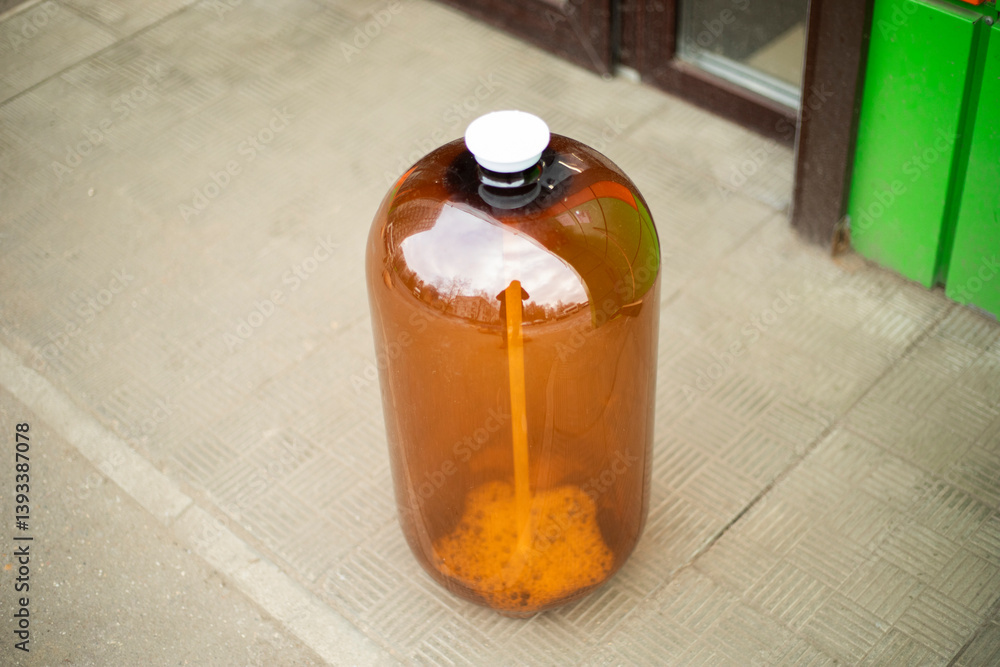 An empty bottle stands on the street. Water canister. Beer bottle