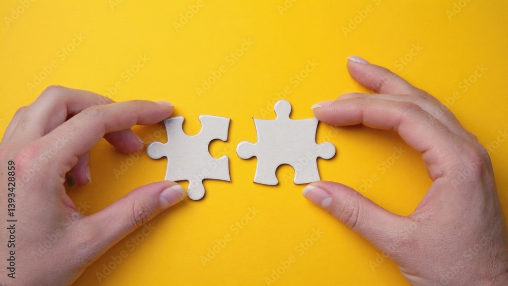Two hands holding two pieces of a puzzle, suggesting completion or unity