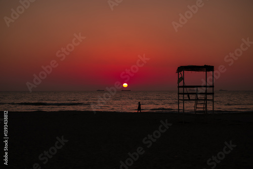 Scenic sunset over the sea in Albania. Vibrant sky with warm orange and pink hues reflecting on the calm water. 