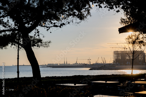 Construction on the seashore near the port of Durres, housing on the seashore. Silhouettes of construction cranes and house frames.