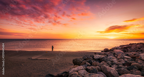 dramatic coastal landscape with colorful dramatic sky with person