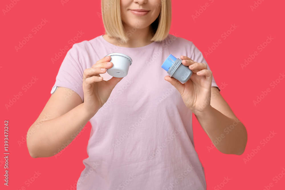 Woman with glucose sensor for measuring blood sugar level and applicator on red background. Diabetes concept Woman with glucose sensor for measuring blood sugar level and applicator on red background. Diabetes concept