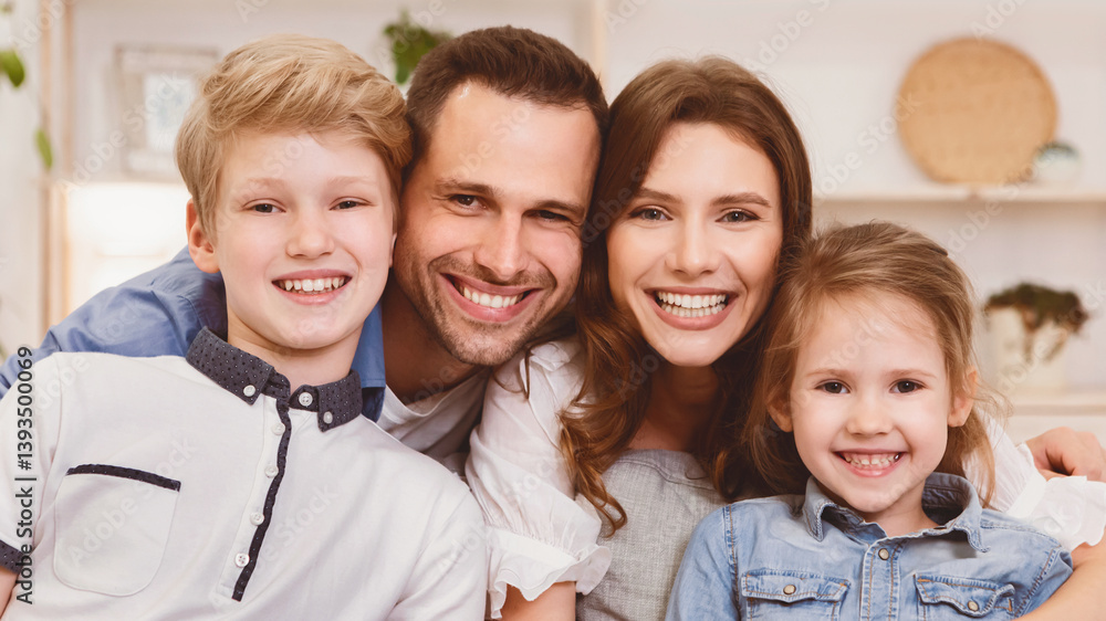 Cute Family Portrait. Smiling Parents And Kids Posing Looking At Camera Sitting On Sofa At Home. Panorama Cute Family Portrait. Smiling Parents And Kids Posing Looking At Camera Sitting On Sofa At Home. Panorama