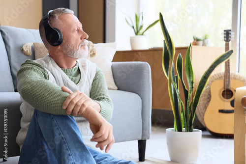 Mature man in headphones li...