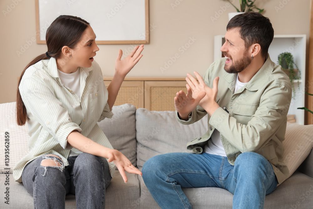 Angry young couple quarreling on sofa at home Angry young couple quarreling on sofa at home