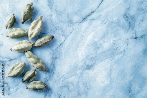 Wallpaper Mural Green cardamom pods scattered on a light blue marble background. Torontodigital.ca