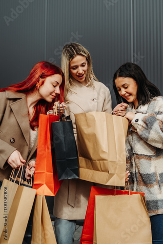 Group of three female friends smile happy and excited with shopping bags