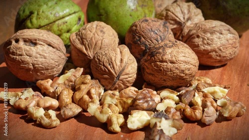 Freshly harvested walnuts panned on wooden board showing shelled and unshelled nuts in rustic natural setting