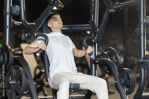 Foto In gym, man uses chest press machine to strengthen arm muscles