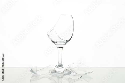 Quadro su tela Pieces of broken wine glass on table against white background