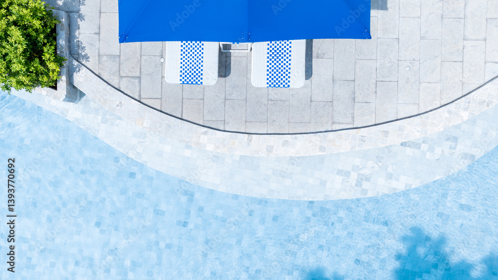 Top view swimming pool blue water in summer with umbrella pool and deck beach chair, Empty swimming pool with sunbed and umbrella pool in resort hotel for vacation leisure, Summer vacation holiday.