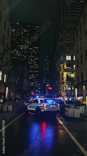 Nighttime police car securing urban street in Manhattan downtown of New York City, vertical video