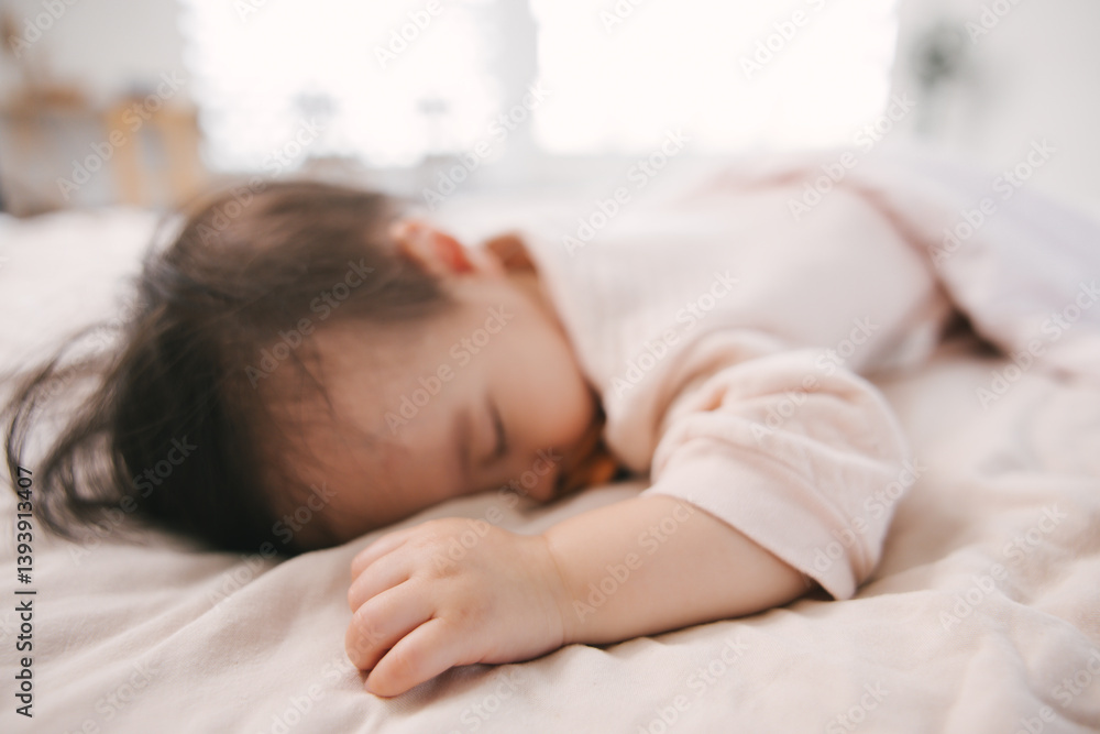 Asian toddler sleeping on bedding. Child with pacifier dressed, resting comfortably with arm outstretched. Bedroom scene. innocence and tranquility of childhood naptime or bedtime routine. Asian toddler sleeping on bedding. Child with pacifier dressed, resting comfortably with arm outstretched. Bedroom scene. innocence and tranquility of childhood naptime or bedtime routine.