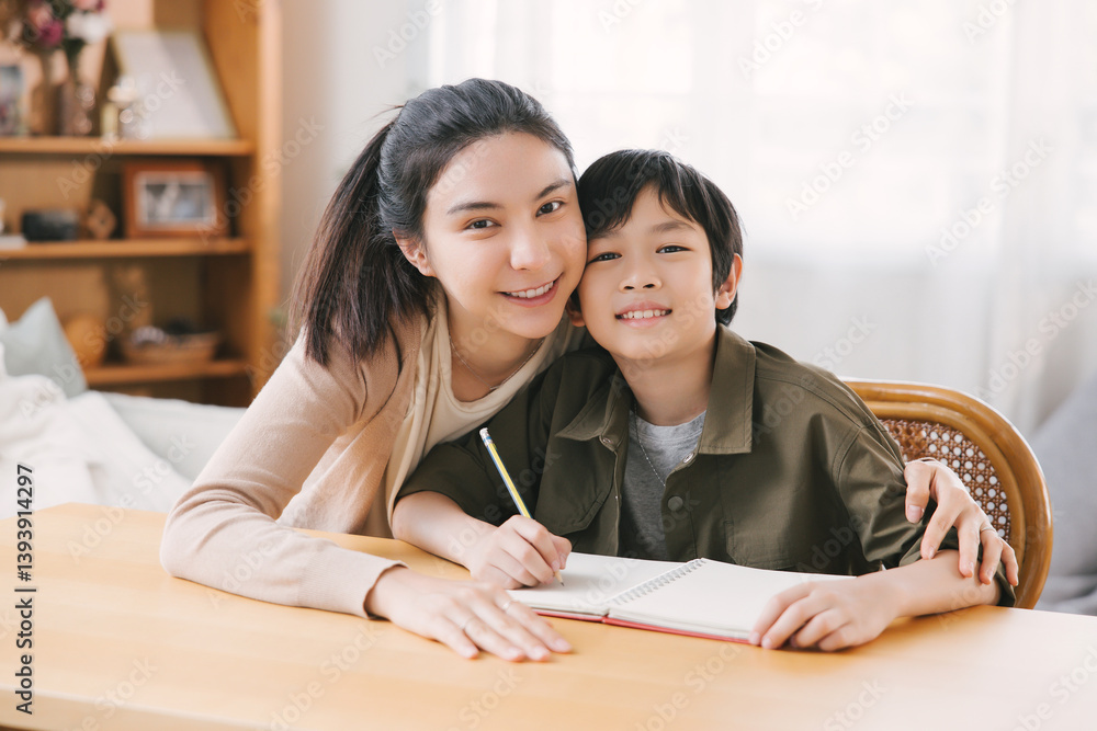 Smiling Asian mother and son bonding while studying at home desk. The room's cozy atmosphere warmth, love, and family inspiration. Ideal for portraying familial relationships and educational moments. Smiling Asian mother and son bonding while studying at home desk. The room's cozy atmosphere warmth, love, and family inspiration. Ideal for portraying familial relationships and educational moments.