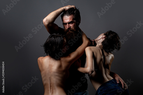 Obraz na płótnie Threesome concept. Three sexy models together. One man and two sexy women. Polygamy or bigamy. Swinger or trio. Bisexual lady. Prostitution or fantasy. Polyamory and polygamy. Romantic of Threesome. w salonie