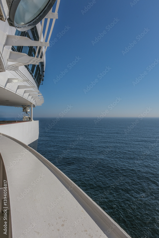 Views onto outdoor teak balcony terrace veranda promenade boat deck of ocean liner cruiseship cruise ship with chairs and loungers at sea during Transatlantic Crossing to New York on beautiful sun day